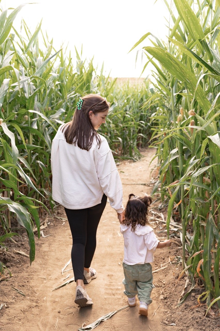 A mom and her daughter walking a path in the corn maze at Palmer's Adventure Farm